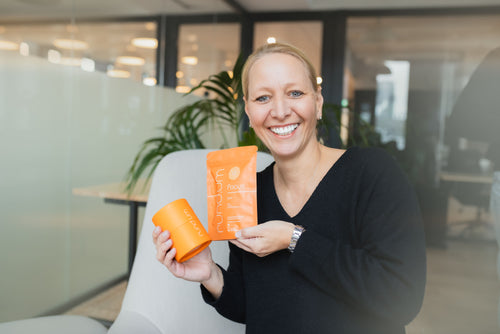 Portrait von Julia mit den focus plus Sticks und der energy Kugel Verpackung in den Händen